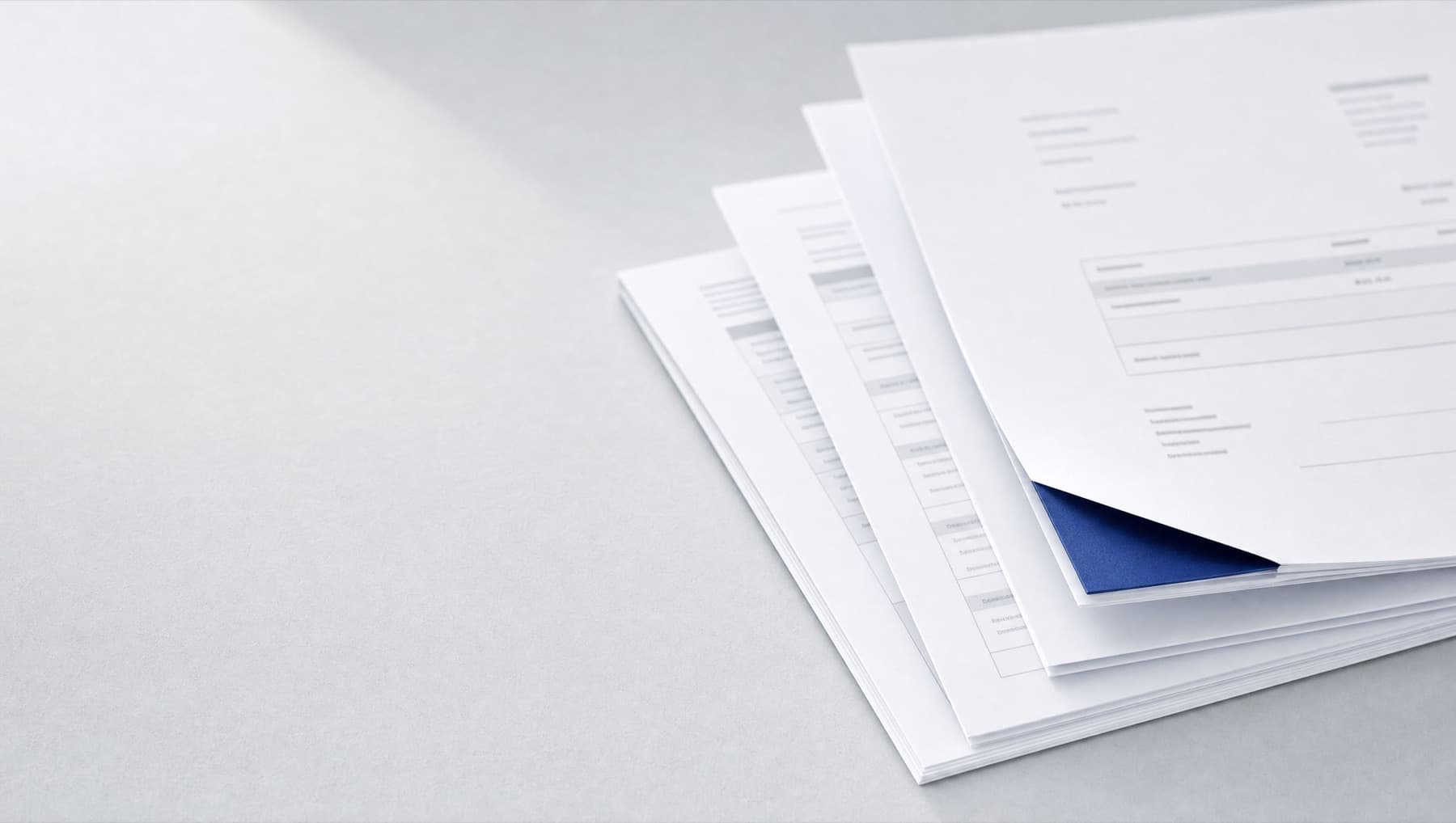 A stack of freshly generated documents, the top one with a cobalt folded corner